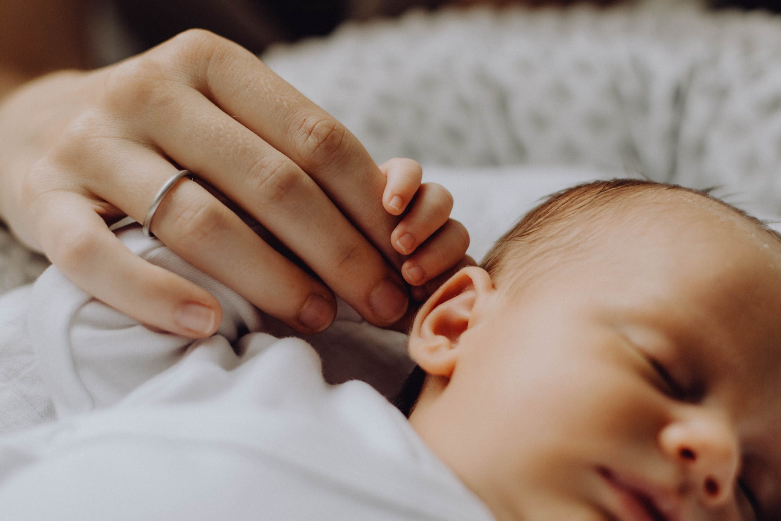 Bild von schlafenden Baby und Hände Eltern
